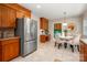 Bright kitchen with stainless steel refrigerator, breakfast nook, wood cabinets, and tile flooring at 1260 Piccadilly Dr, Charlotte, NC 28211