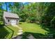 Backyard storage shed surrounded by well-manicured lawn and green foliage at 1260 Piccadilly Dr, Charlotte, NC 28211