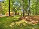 The big green yard features a brick home with french doors, complemented by tall trees and a shed at 1325 Rock Point Rd, Charlotte, NC 28270