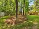Spacious backyard with mature trees, landscaping, and a shed in the distance at 1325 Rock Point Rd, Charlotte, NC 28270