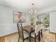 Well-lit dining room featuring a dark wood table, upholstered chairs, wainscoting, and an abstract painting at 1325 Rock Point Rd, Charlotte, NC 28270