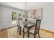 Elegant dining room with a classic chandelier, a dark wood table, upholstered chairs, and natural light at 1325 Rock Point Rd, Charlotte, NC 28270