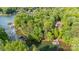 Aerial view of a lake house surrounded by mature trees with a private dock and boat slip at 135 Sumter Dr, Mooresville, NC 28117