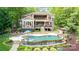 Expansive backyard featuring a luxurious pool, spa, stone terraces, and lush landscaping at 135 Sumter Dr, Mooresville, NC 28117