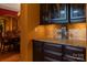 Butler's pantry with granite countertops, dark wood cabinets, and tile backsplash at 135 Sumter Dr, Mooresville, NC 28117