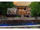 A large home overlooks the in-ground pool with a stone waterfall and a covered patio with a pergola at 135 Sumter Dr, Mooresville, NC 28117