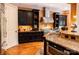 Gourmet kitchen featuring stainless steel appliances, granite countertops, dark wood cabinets, and center island at 135 Sumter Dr, Mooresville, NC 28117