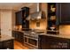 Close-up of kitchen with stainless steel range, granite countertops, tile backsplash, and dark wood cabinets at 135 Sumter Dr, Mooresville, NC 28117