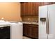 Spacious laundry room featuring updated appliances, cabinets, sink, granite countertops and a side-by-side refrigerator at 135 Sumter Dr, Mooresville, NC 28117