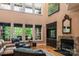 Bright living room with large windows, stone fireplace, built-in shelving, and comfortable leather furniture at 135 Sumter Dr, Mooresville, NC 28117
