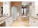 Luxurious bathroom with glass block shower, soaking tub, granite countertops, and travertine floors at 135 Sumter Dr, Mooresville, NC 28117