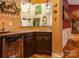 Interior wet bar with granite countertops, dark wood cabinets, and overhead wine glass rack at 135 Sumter Dr, Mooresville, NC 28117