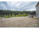 Large backyard with green trees in the background and outdoor kitchen great for gatherings at 150 Falls Cove Dr, Troutman, NC 28166