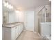 Bathroom featuring a double sink vanity with granite countertop and a tiled walk-in shower with glass door at 150 Falls Cove Dr, Troutman, NC 28166