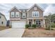 Charming two-story home featuring a two-car garage and a welcoming front porch with stone accents at 150 Falls Cove Dr, Troutman, NC 28166