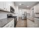 Modern kitchen features granite countertops, white cabinets, stainless steel appliances, and hardwood floors at 150 Falls Cove Dr, Troutman, NC 28166