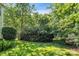 Scenic backyard with a lush lawn and mature trees providing privacy at 15000 Strathmoor Dr, Charlotte, NC 28277