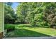 Lush backyard with mature trees provides a private and serene outdoor space at 15000 Strathmoor Dr, Charlotte, NC 28277