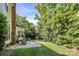 A spacious backyard with patio seating and lush green trees at 15000 Strathmoor Dr, Charlotte, NC 28277