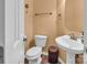 Cozy powder room features a pedestal sink, toilet, and towel rack with neutral wall color and fixtures at 15000 Strathmoor Dr, Charlotte, NC 28277