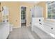 Bright bathroom featuring a separate tub and shower, tile floors, and natural light at 15000 Strathmoor Dr, Charlotte, NC 28277