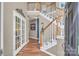 Elegant foyer featuring hardwood floors, staircase with white railings, and french doors leading to another room at 15000 Strathmoor Dr, Charlotte, NC 28277