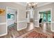 Spacious hallway featuring hardwood floors, white trim, and views into the kitchen and the office space at 15000 Strathmoor Dr, Charlotte, NC 28277
