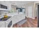 Open kitchen showcasing white cabinets and countertops, an electric range, and a view into the living area at 15000 Strathmoor Dr, Charlotte, NC 28277
