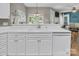 Bright kitchen features white cabinetry, a spacious countertop and sink area, and view to the living area at 15000 Strathmoor Dr, Charlotte, NC 28277