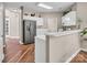 Open kitchen design features white cabinets, stainless steel appliances, and seamlessly connects to other living spaces at 15000 Strathmoor Dr, Charlotte, NC 28277