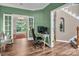 Home office with hardwood flooring, built-in shelves, bay window and a view into other rooms at 15000 Strathmoor Dr, Charlotte, NC 28277