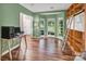 Green office featuring a bay window, hardwood floors, and a custom bookshelf with an included ladder at 15000 Strathmoor Dr, Charlotte, NC 28277