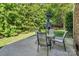 A backyard patio features seating, an umbrella, and green scenery at 15000 Strathmoor Dr, Charlotte, NC 28277