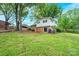 View of the back of the house with an open backyard and trees at 1521 19Th Sw St, Hickory, NC 28602