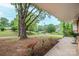 Lush front yard view showcasing mature trees and landscaping from a covered porch at 1521 19Th Sw St, Hickory, NC 28602