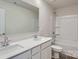 Bright bathroom features a double sink vanity with white countertops, a large mirror, and tub with white tiling at 1703 Wooten Way, Bessemer City, NC 28016