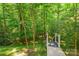 Backyard with steps going down into the green foliage and forest at 17219 Grand Central Way, Cornelius, NC 28031