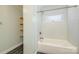 Nicely tiled bath and shower with glass shelf and white porcelain tub at 17219 Grand Central Way, Cornelius, NC 28031