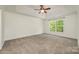 Bedroom with carpet, a ceiling fan, and a window that offers an outside view at 17219 Grand Central Way, Cornelius, NC 28031