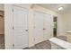 Bright hallway with multiple doors, storage closet, and hardwood floors at 17219 Grand Central Way, Cornelius, NC 28031