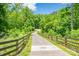 A paved path through a green area with a wooden fence, offering a scenic walking or biking route at 17219 Grand Central Way, Cornelius, NC 28031