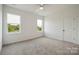 Bedroom with carpet, two windows with treed view, ceiling fan, and a white door at 175 Lone Pine Rd, Statesville, NC 28625