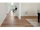 Bright hallway with hardwood floors leading to a living area with a fireplace and staircase at 175 Lone Pine Rd, Statesville, NC 28625