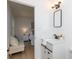 Light-filled bathroom showcasing a vanity, mirror with light fixture, and partial view into an adjacent bedroom at 1757 Ashcroft Ln, Rock Hill, SC 29732