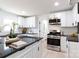 Bright kitchen featuring white cabinets, black countertops, stainless steel appliances, and an island with stool seating at 1757 Ashcroft Ln, Rock Hill, SC 29732