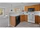 Functional kitchen with wood cabinets, white appliances, and a window view at 183 Bellelaine Dr, Mooresville, NC 28115