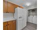 A practical kitchen with wood cabinetry leads into a laundry room with a modern washer and dryer at 183 Bellelaine Dr, Mooresville, NC 28115