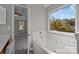 A soaking tub in the main bathroom is set beneath a sunny window for relaxation at 183 Bellelaine Dr, Mooresville, NC 28115