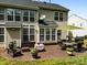 This outdoor patio features elegant patio furniture and large windows providing scenic views of the private backyard at 1900 Birchbrook Ct, Harrisburg, NC 28075