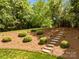 This backyard features manicured landscaping, and stone steps at 1900 Birchbrook Ct, Harrisburg, NC 28075